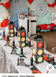 there are many traffic lights on the table at this birthday party with balloons in the background