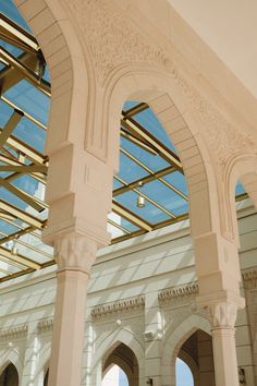 the inside of an ornate building with arches and windows on both sides, against a blue sky background