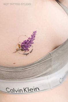 a woman's stomach with a small purple flower tattoo on her left side belly