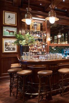 a bar with several stools and bottles on the top shelf in front of it