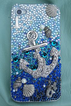 a cell phone case with an anchor and shells on the front, sitting on a blue background