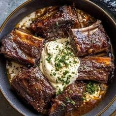 a bowl filled with meat and sauce on top of a table