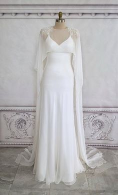 a white wedding dress on a mannequin with an open back and long sleeves