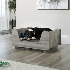 a black and white dog laying on top of a wooden bed in a living room