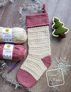 two crocheted socks and balls of yarn on a wooden floor