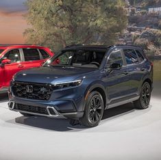 three different colored cars on display at an auto show