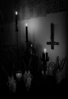 candles are lit in the corner of a dark room