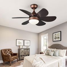 a bedroom with a bed, chair and ceiling fan