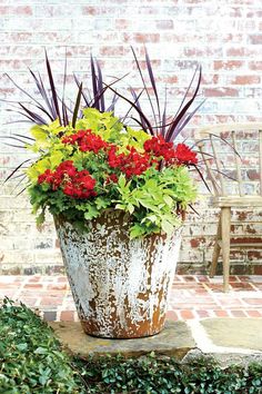 a potted plant sitting on top of a stone bench next to a brick wall