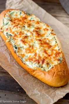 a cheesy bread is sitting on wax paper