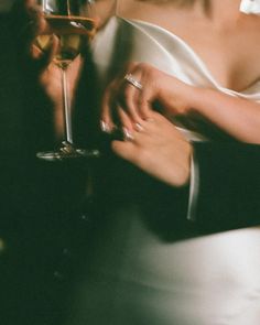 a woman in a white dress holding a glass of wine