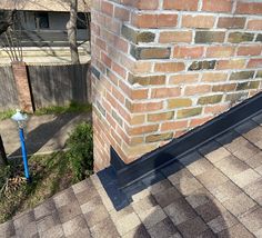 the corner of a brick building next to a blue pole