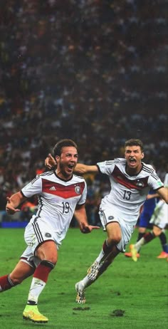 two soccer players are celebrating on the field