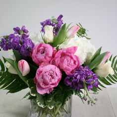 a vase filled with lots of purple and white flowers