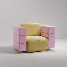 a pink and yellow chair sitting on top of a white floor next to a wall