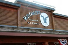 the front of a building with an ice cream shop sign on it's side