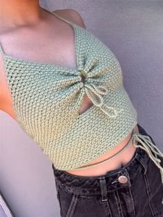 a woman wearing a green knitted top with a bow