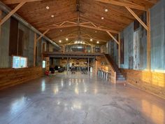 the inside of a large building with wooden walls and beams on the ceiling is empty