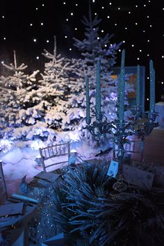 an outdoor christmas display at night with lit up trees and snowflakes on the ground