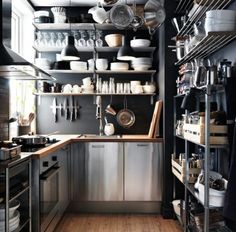 a kitchen with lots of pots and pans on the shelves above the stove top