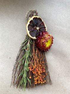 an orange and some dried flowers on the ground