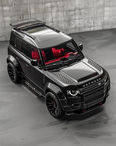 a black land rover is parked in an empty space with red lights on the hood