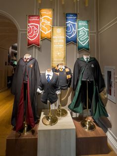 several harry potter costumes on display in a museum