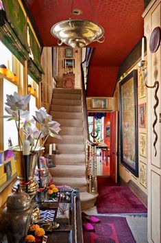 the hallway is decorated with colorful rugs and flowers in vases on the table