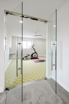 an exercise room with glass walls and mirrors