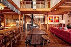 a living room filled with furniture next to a fire place stove top oven under a wooden ceiling