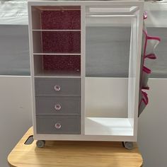 a white and grey cabinet with drawers on wheels