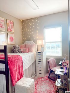 a bedroom decorated in pink and white with lights on the wall above the bed, along with a teddy bear