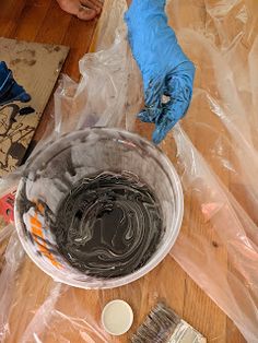 a person in blue gloves and rubber gloves cleaning a bowl on a table with other items