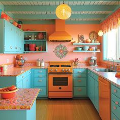 an orange and blue kitchen with lots of cupboards on the wall above the stove