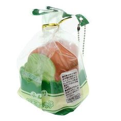 a plastic bag filled with assorted fruit on top of a white background and green trimming