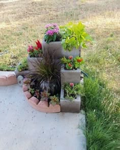 several planters are arranged in the shape of three pyramids with plants growing out of them