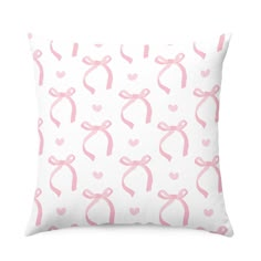 a pillow with pink bows and hearts on it, in front of a white background