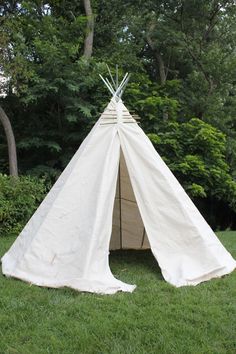 a teepee sitting on top of a lush green field