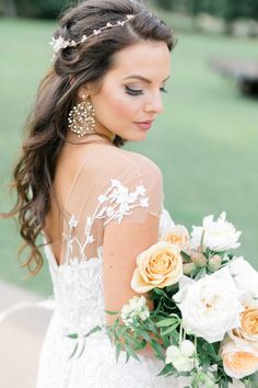 a woman in a wedding dress holding a bouquet of flowers and wearing a tiara