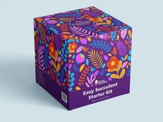 a purple box with colorful floral designs on the front and sides, sitting on a blue background