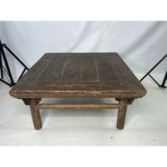 an old wooden table sitting on top of a white floor