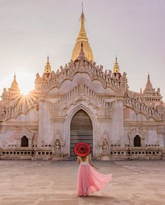 a woman standing in front of a building with a red wreath on it's head