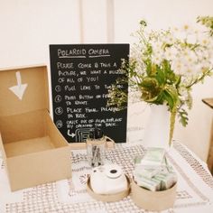 an open box sitting on top of a table next to a vase filled with flowers