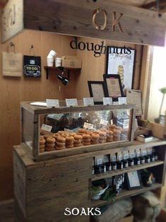 a display case filled with lots of different types of doughnuts on top of wooden shelves