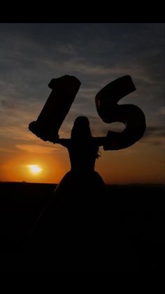 the silhouette of a woman in a dress with her arms outstretched and number six on it