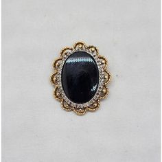 Circa 1980s goldtone oval smooth faux-onyx center with tiny round clear rhinestones surround brooch with security clasp and loop to be worn as a pendant. Measures: 1 3/8 inches long by 1 1/8 inches wide. Condition: Very good; a few of the tiny clear rhinestones have darkened, but they're so small it's not very noticeable. Black Metal Brooch Jewelry, Gold Oval Brooch For Evening, Elegant Black Cameo Brooches, Oval Costume Jewelry Brooch, Oval Brooches For Evening, Oval Evening Brooches, Gold Brooches, Pearl Brooch, Georg Jensen