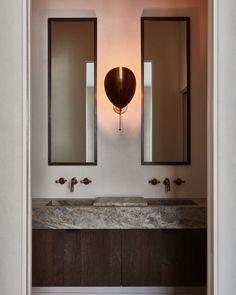 a bathroom with two sinks and mirrors on the wall