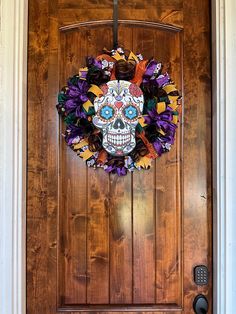 a wooden door with a sugar skull wreath on it