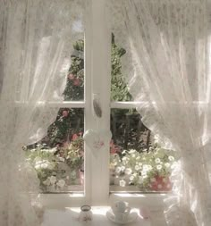 there is a window with white curtains in the room and flowers on the windowsill