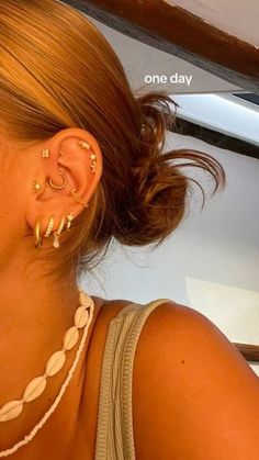 a close up of a person with ear piercings on their ears and wearing jewelry